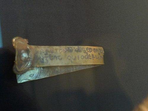 The folded gold strip inscribed with a verse from Numbers 10:35.