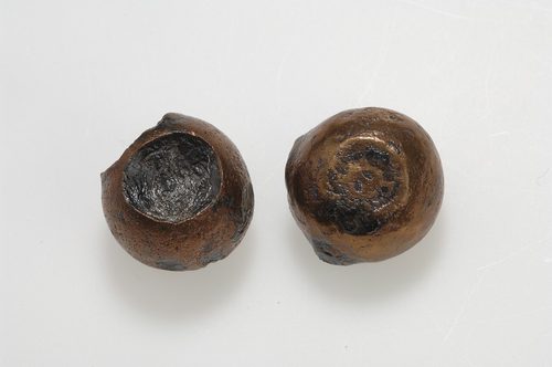 Two oblate-spheroid weights, iron cased in bronze, from the same Birka grave, Swedish History Museum.