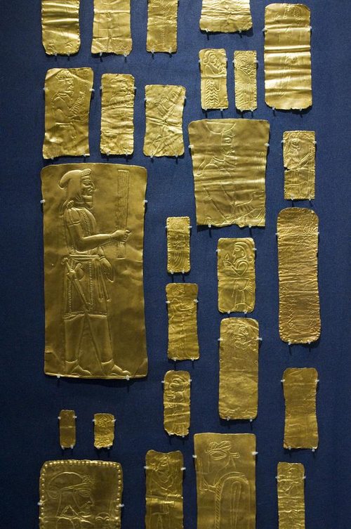 Gold votive plaques incised with figures.