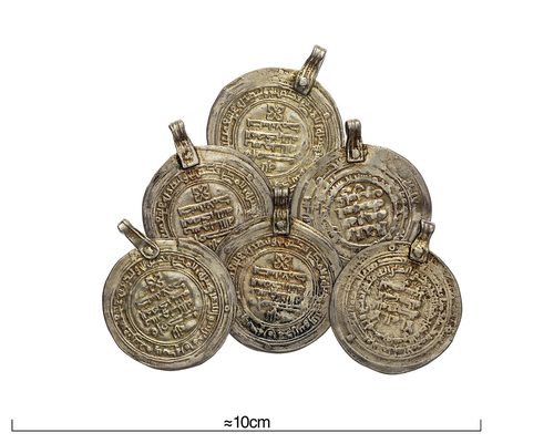 Dirhams and imitation dirhams fitted with loops as pendants. Swedish History Museum.