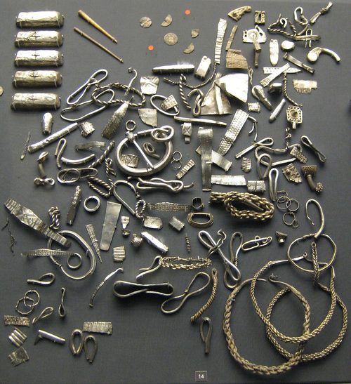 Ingots, neck-rings and coins from the hoard as displayed in the British Museum.