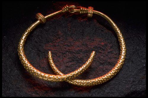 The neck-ring opened, showing its two crossed gold rods.