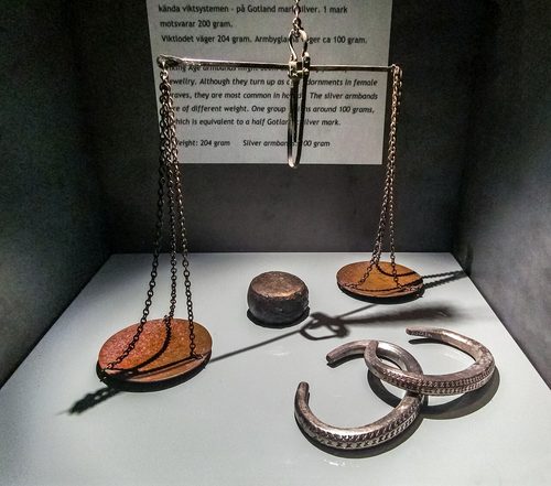 A balance with weights beside arm-rings made to about 100 g, Spillings Hoard, Gotland Museum, Visby.