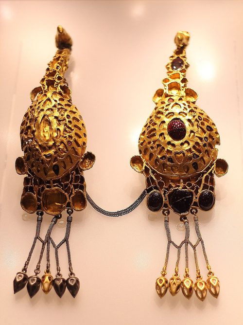 A pair of eagle-headed brooches set with garnets.