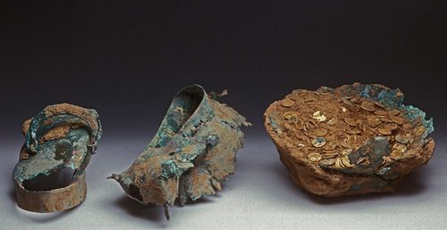 The torn bronze cauldron with coins still inside, as found.